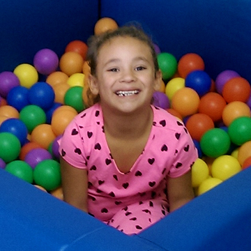 Girl playing in a ball pit