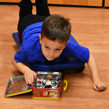 Boy doing occupational therapy on his belly