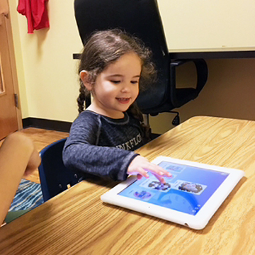 Girl using an iPad for speech therapy