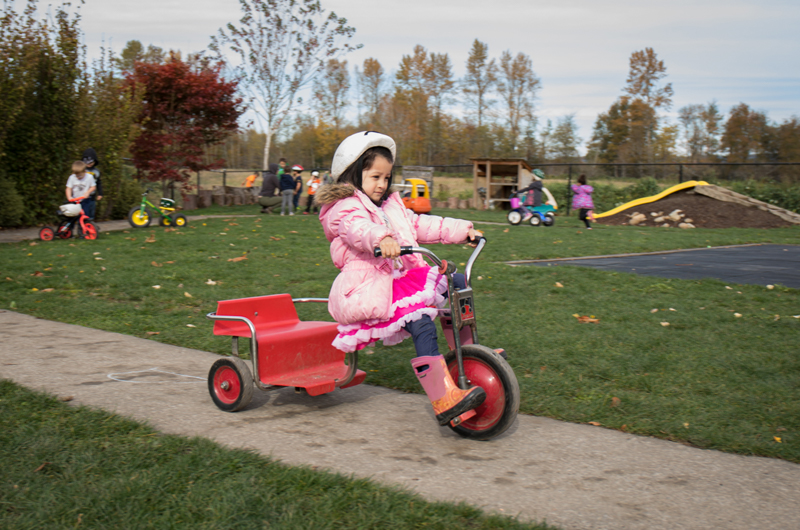 Little girl riding on a tricycle