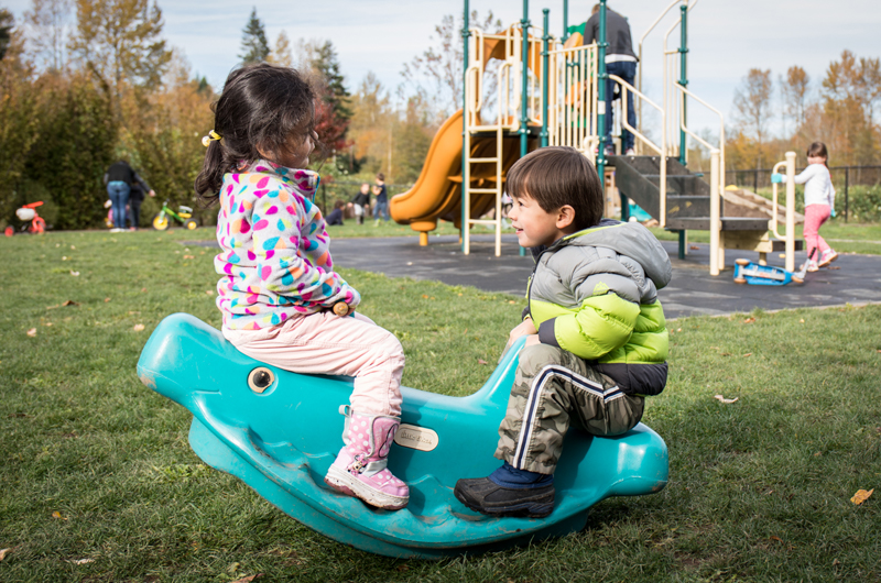 Boy and girl play on a seesaw