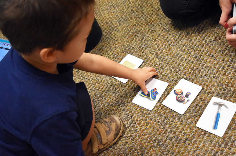 Boy picking up cards with pictures on them