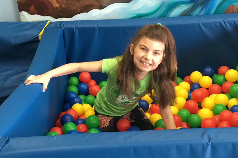 Girl playing in the ball pit