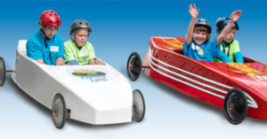 Four people riding in soapbox derby cars