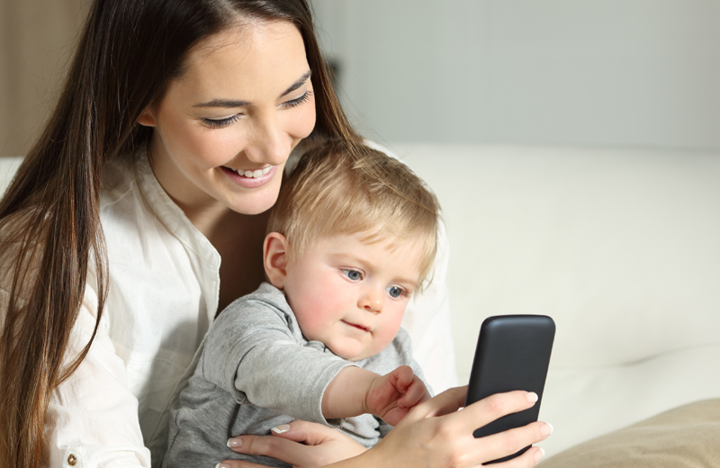 Woman and little boy look at a cell phone