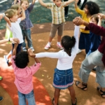 teacher holding hands with kids outside