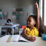 young girl raising her hand