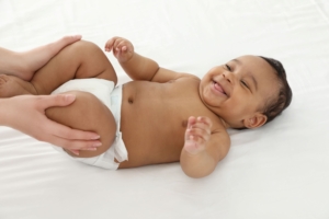 Smiling baby getting legs massaged