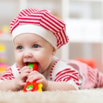 Baby on tummy chewing a toy