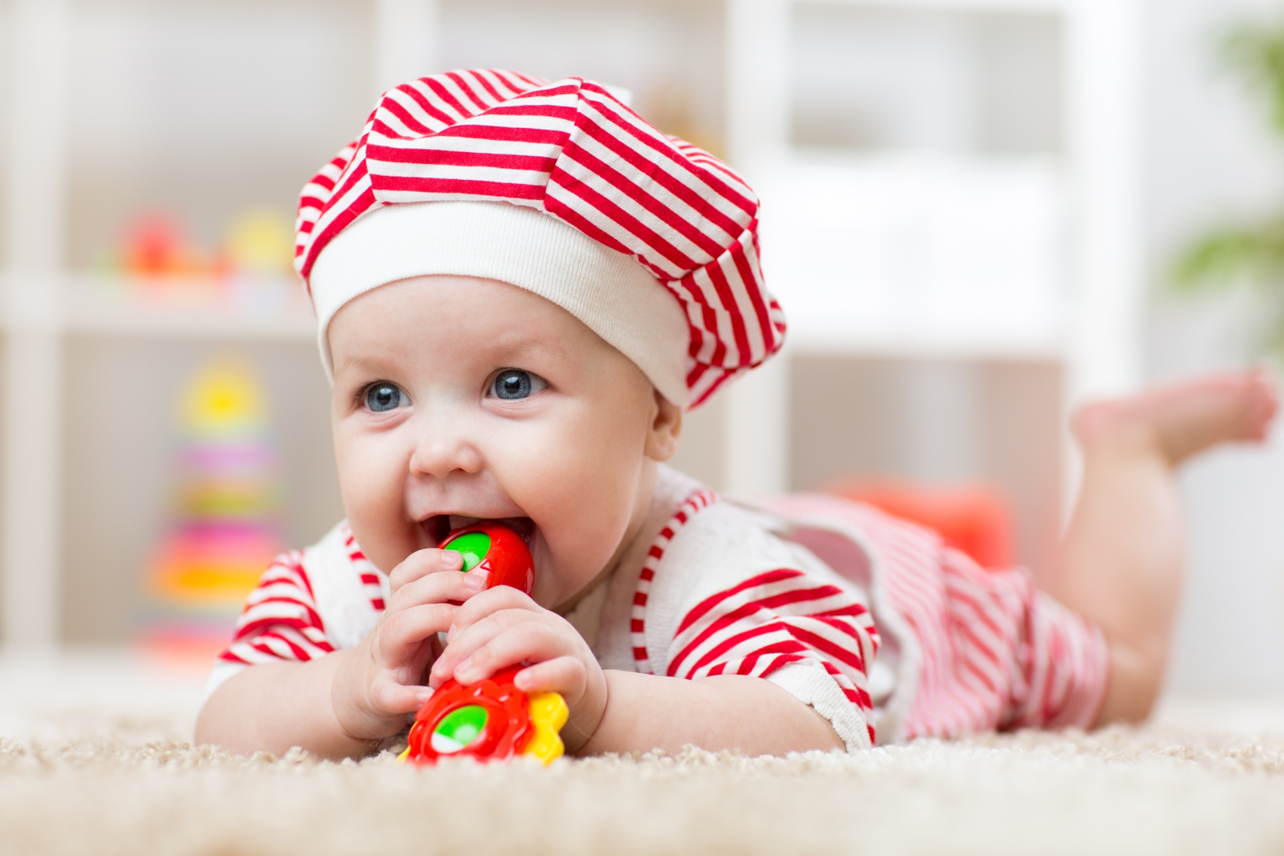 Baby on tummy chewing a toy