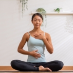 Woman doing breathing exercise with hands on chest and stomach