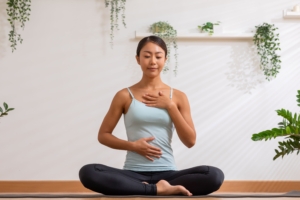 Woman doing breathing exercise with hands on chest and stomach