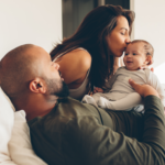 Parents kissing their baby